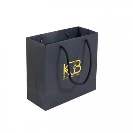 neue gold logo heißfolienprägung schwarz matt kraftpapiertüte mit baumwollseilgriffen